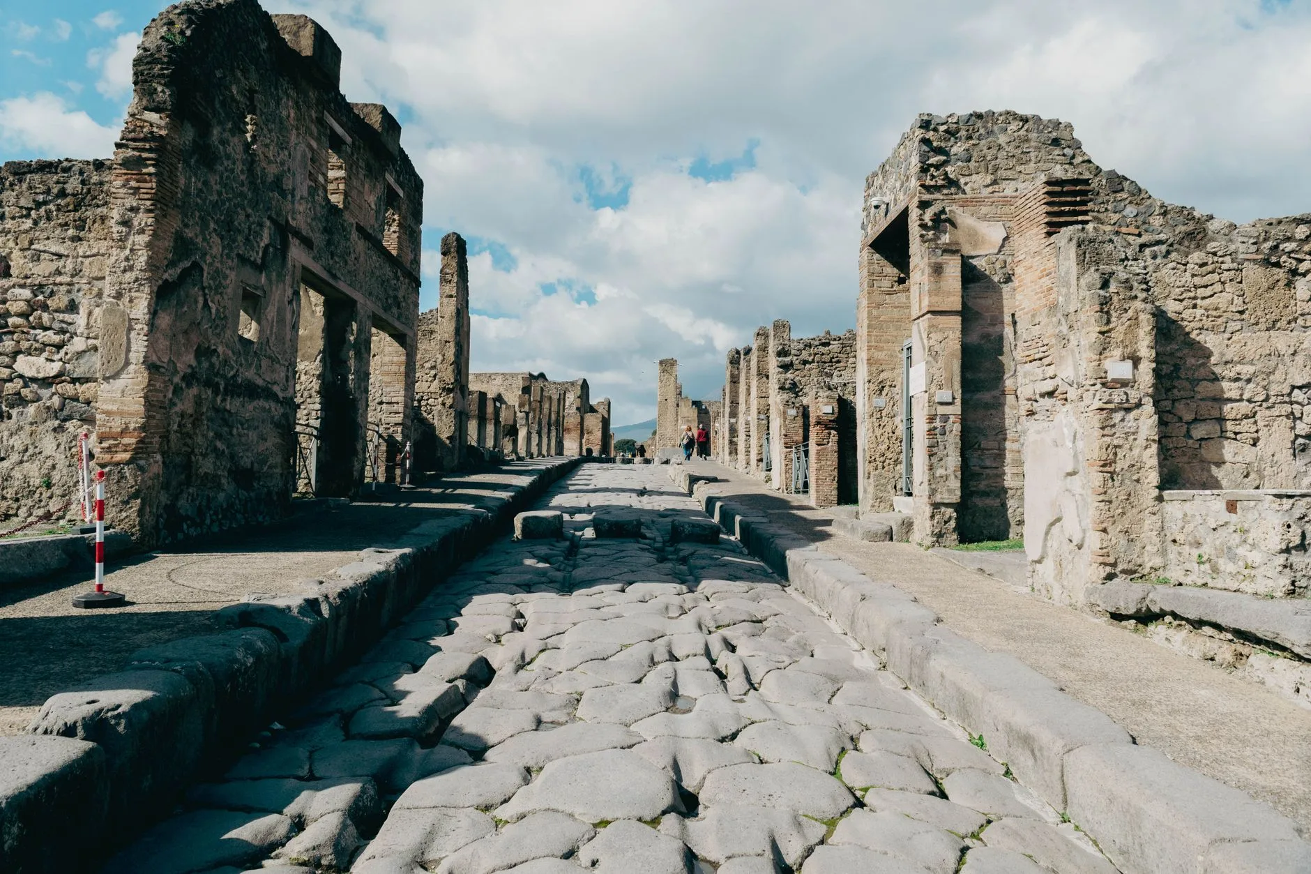 Rue pavée et ruines de Pompéi avec le Vésuve en arrière-plan